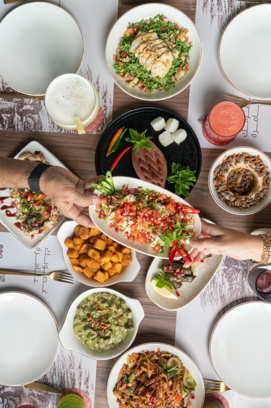 friends sharing a lebanese mezze table at ghusoun restaurant in jeddah